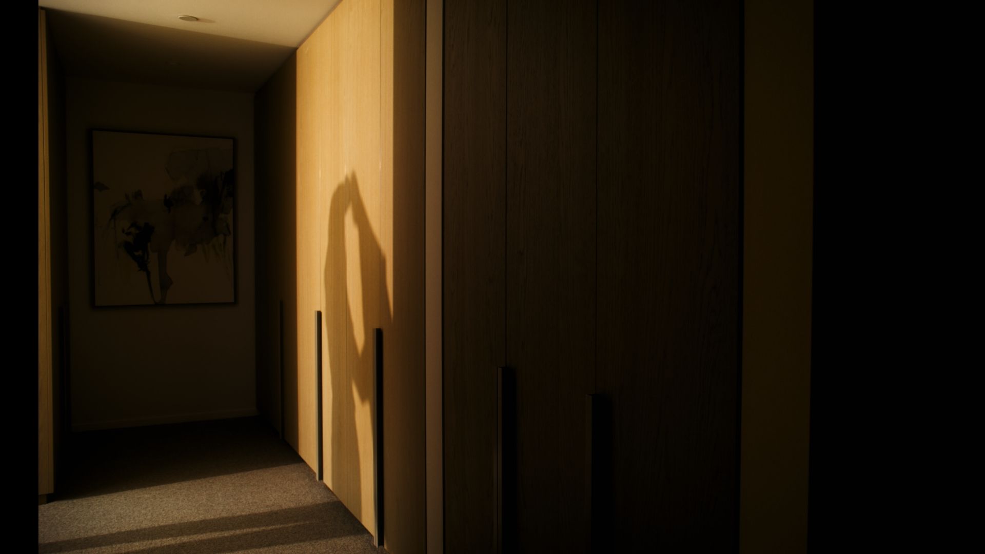 A reflection of a shaow on the cupboard of a person putting on a jacket.  | The International, Brighton developed by Landream & V-Leader | Architecture by Carr | Architectural Film by Veeral Patel
