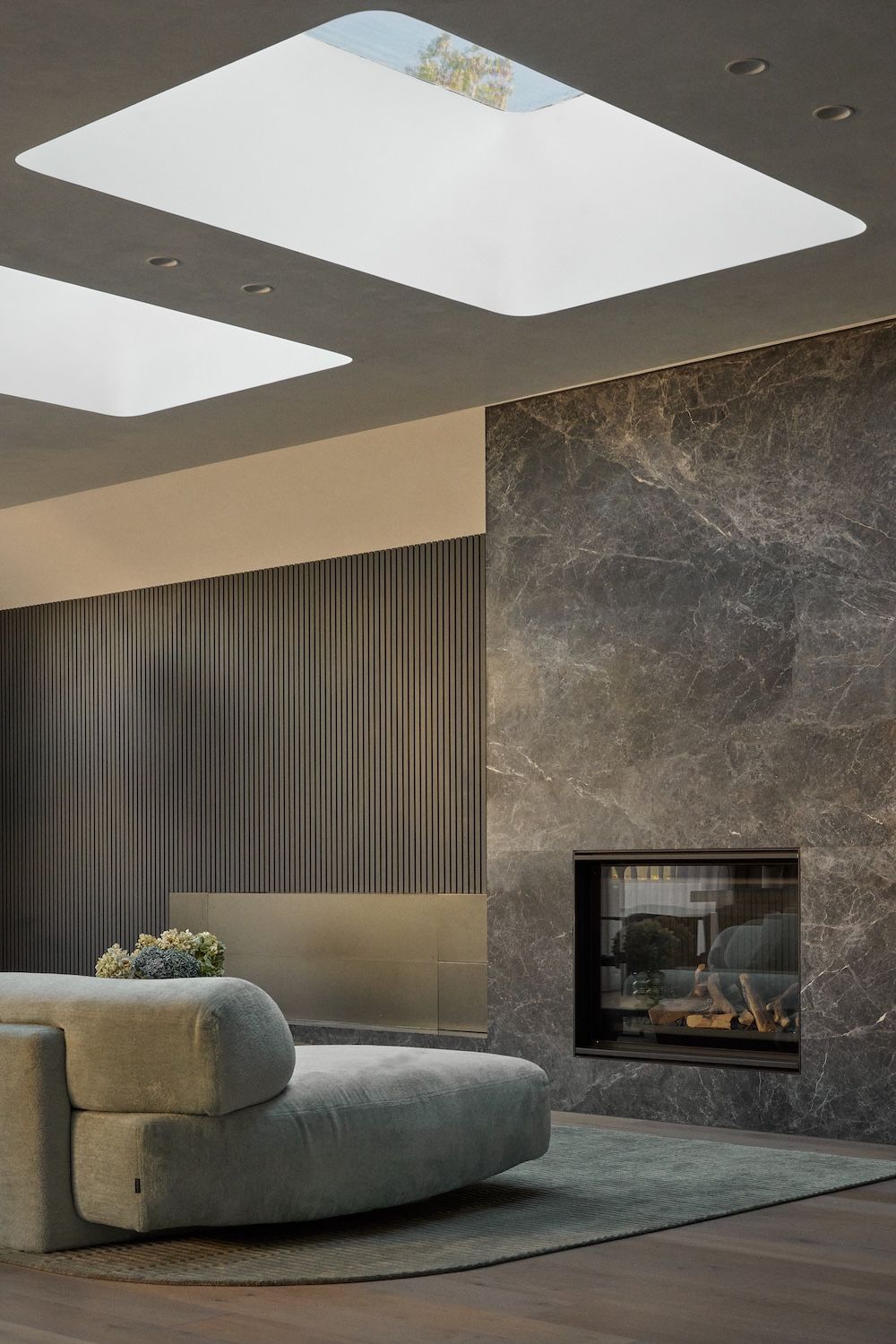A glimpse of the living room with two large rectangular skylights and a gas log fireplace.  | Straun Residences interior architecture by Mim Design and built by Virgon Constructions | Mim Design | Toorak, Victoria | Architectural Photography Veeral Patel