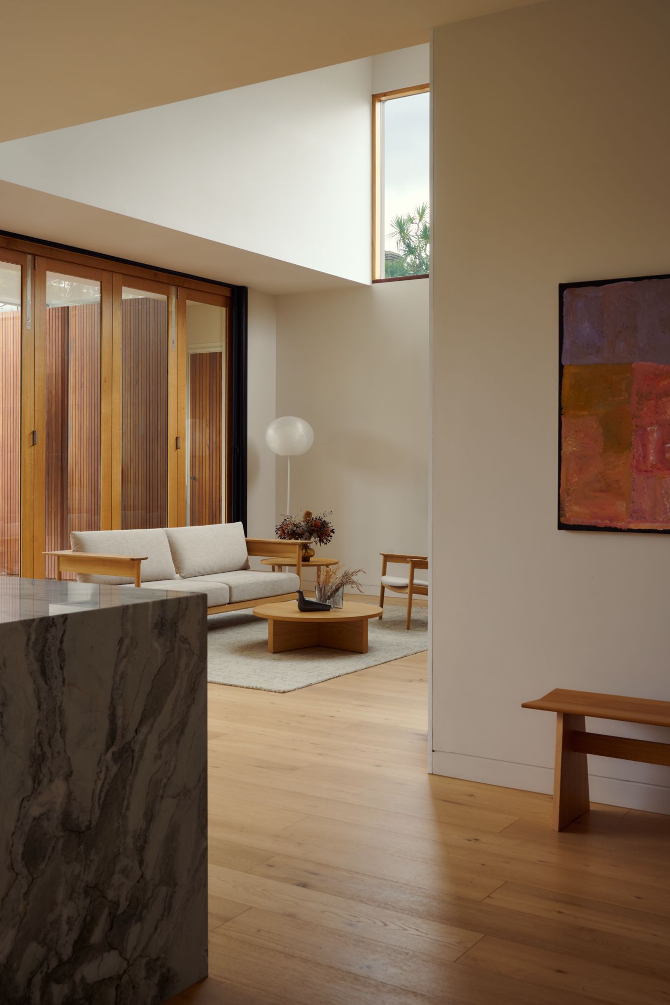 Glimpse of the living room from the dinning table, catching the edge of the marble island.  | College Street by RCA Studio and Built By Manor | Hawthorn | Veeral Patel