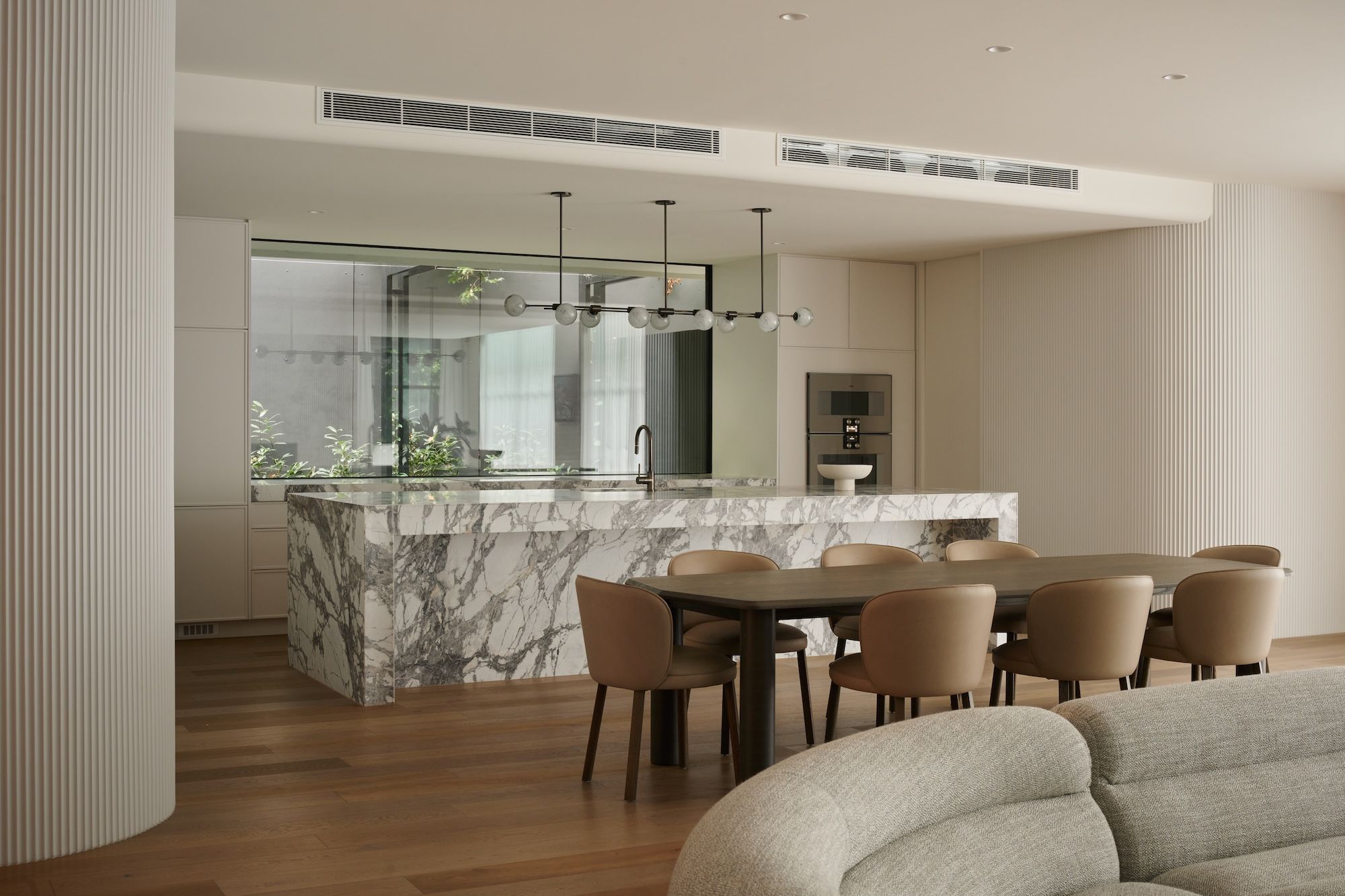 Showing the full length of the kitchen together with the Arte dinning table and chairs designed by Jardan.  | Straun Residences interior architecture by Mim Design and built by Virgon Constructions | Mim Design | Toorak, Victoria | Architectural Photography Veeral Patel
