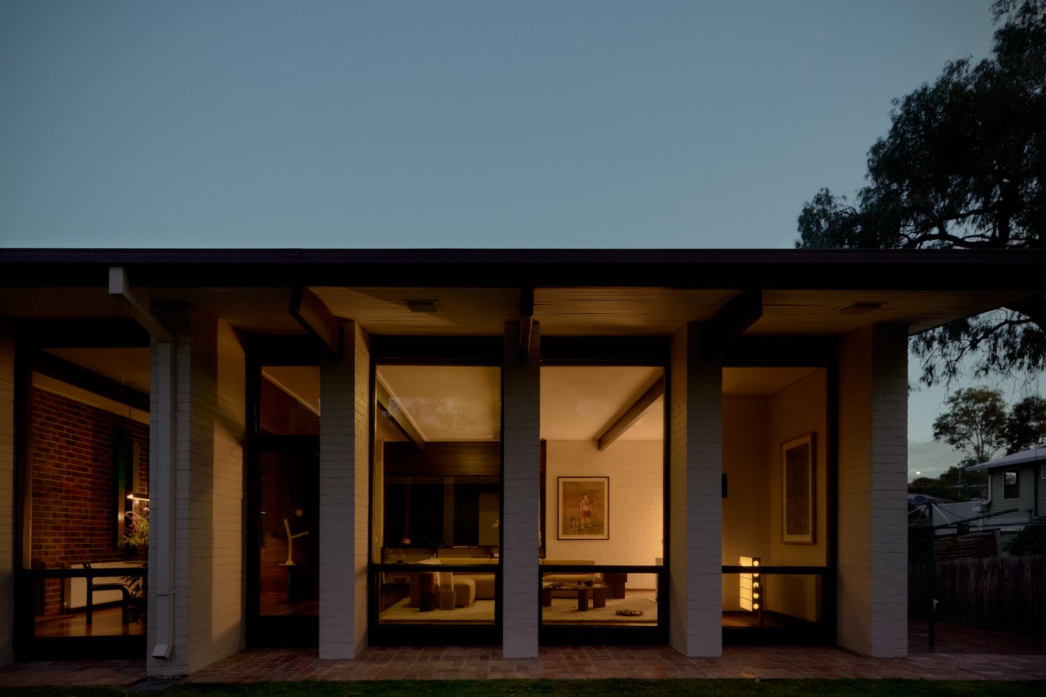 Wildwood in the winter evening as light glows in-between the colonnades. | Wildwood by Robin Boyd | Vermont, Victoria | Noble family | Architectural Photography by Veeral Patel
