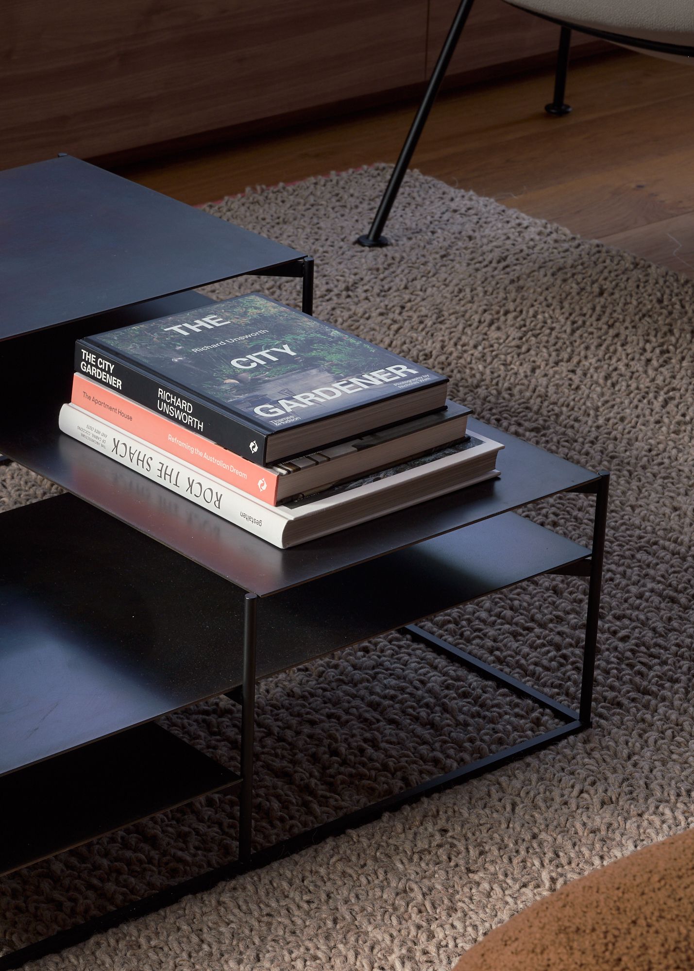 A close up of the black metal coffee table with a pile of books. Supplied by Domo.   | Peavey Residence II by FYC Architects and Snakes & Ladders Projects | Prahran | Veeral Patel