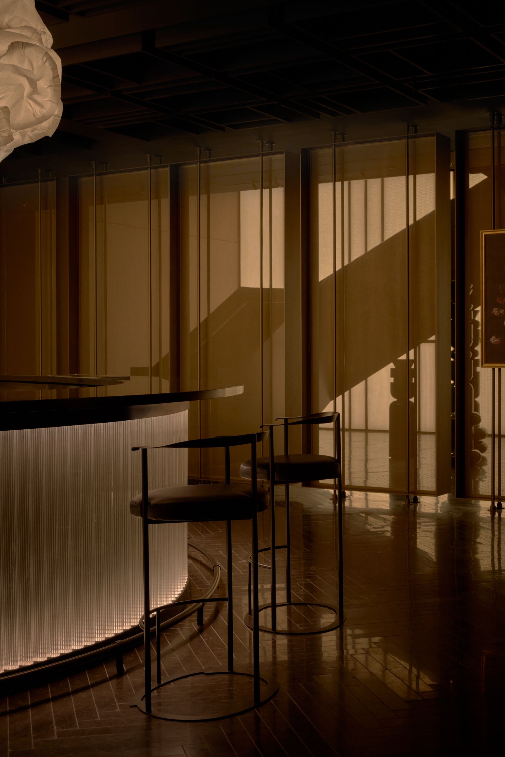 A corner of the bar looking towards the screen showing the folded metal staircase. The guest room inside AKA Alexandria. The seating area alongside the glass wall of the restaurant of AKA Alexandria.  | AKA Hotel Alexandria | Alexandria, Virginia, USA | Architecture and Interiors by Lissoni Partners | Photography by Veeral Patel