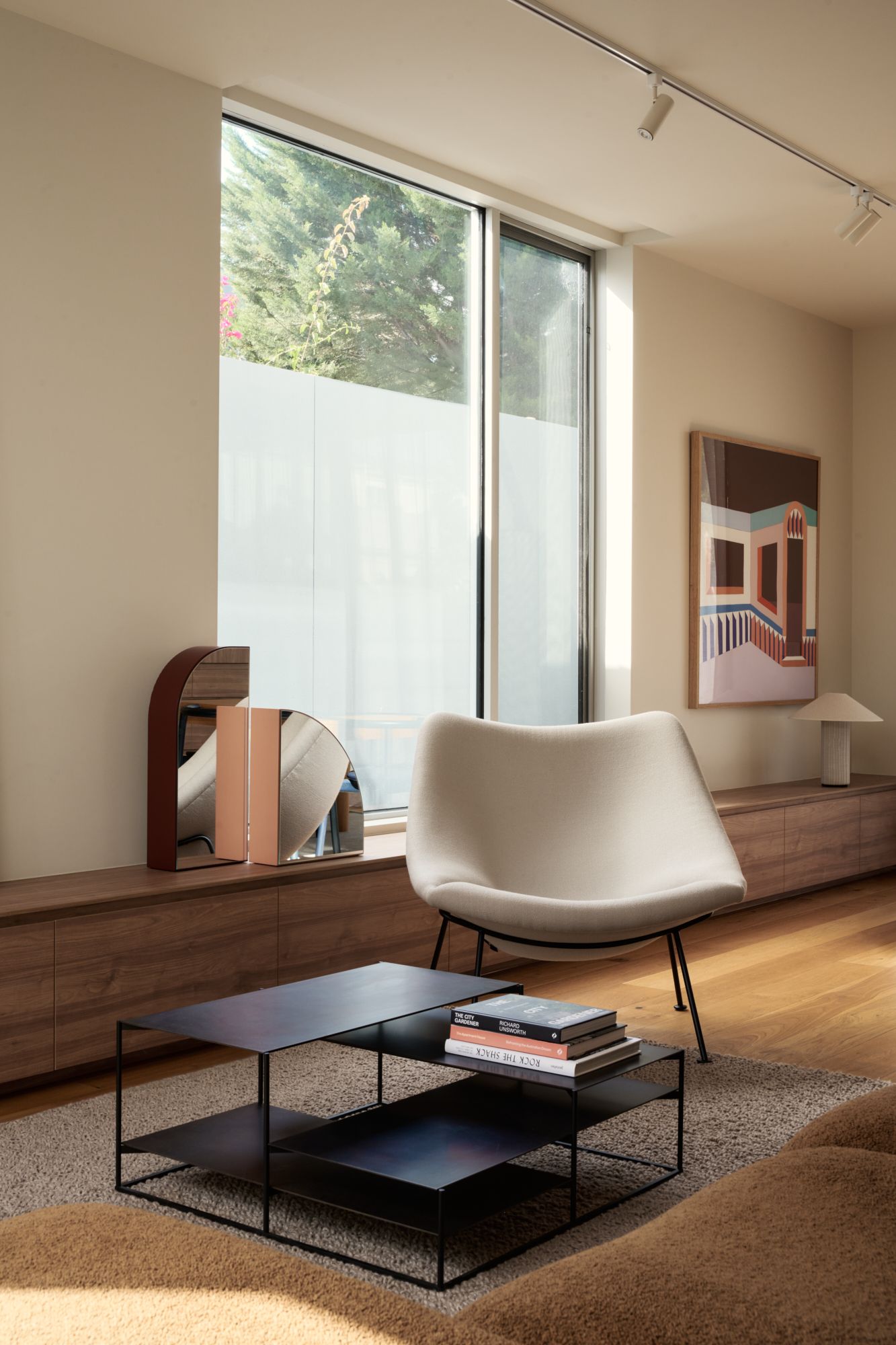 An oblique view of the living room with a wooden plinth running lengthways. Arm chair and coffee table from Domo.   | Peavey Residence II by FYC Architects and Snakes & Ladders Projects | Prahran | Veeral Patel
