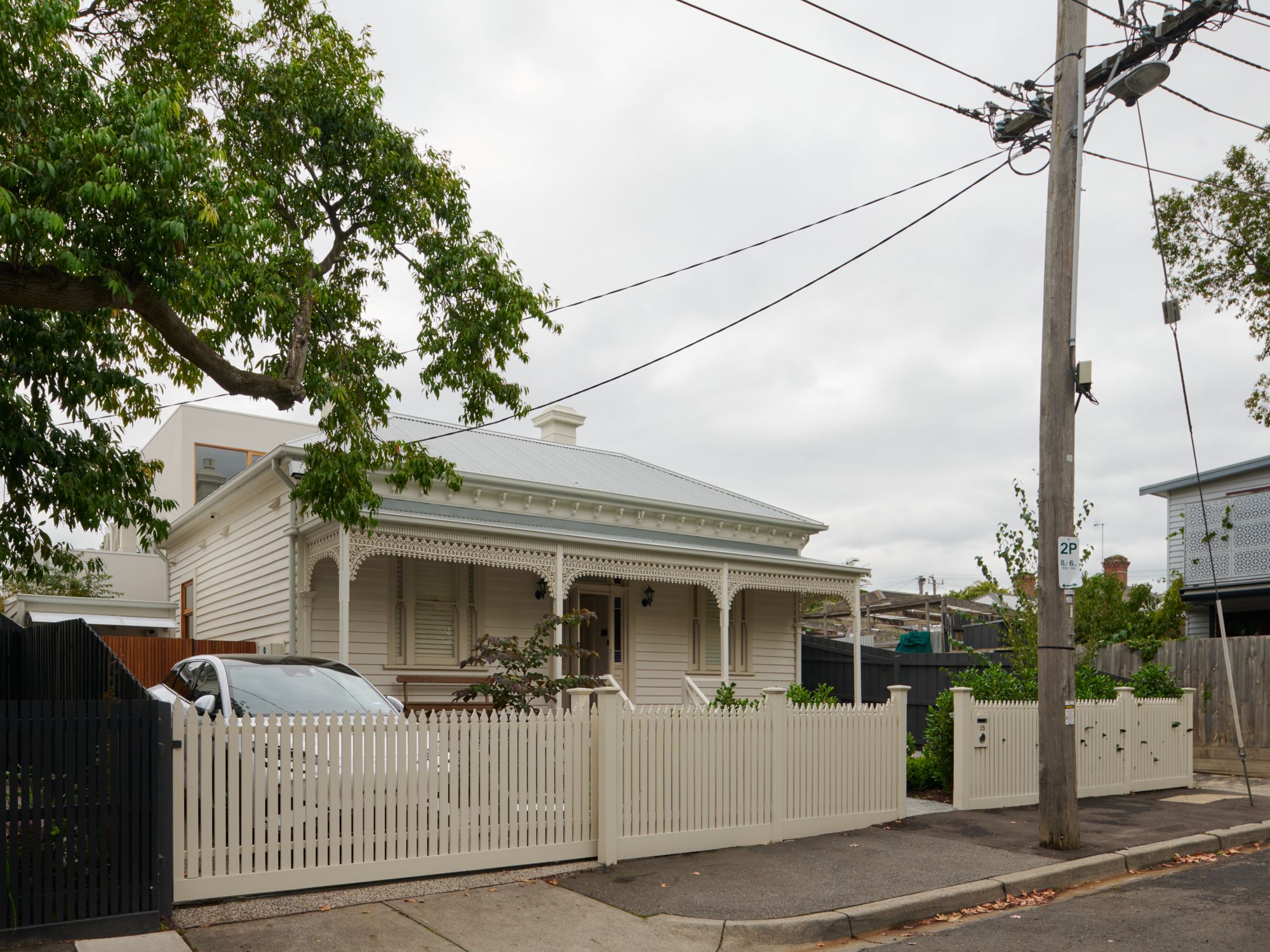 An oblique image of the front of the house with white picket fence and the extension at the rear of the house.  | College Street by RCA Studio and Built By Manor | Hawthorn | Veeral Patel