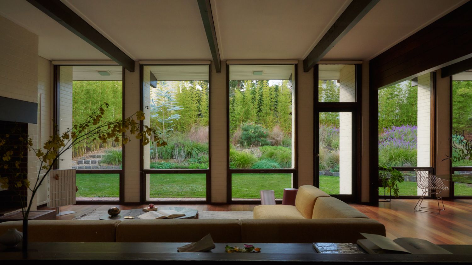 A view from the living room of Wildwood into the lush garden. Views through the floor to ceiling glass framed by colonnades. A garden view of Wildwood showing the depth of the colonnades. | Wildwood design by Robin Boyd | Vermont, Victoria | Midcentury Architecture | Architectural Photography by Veeral Patel 