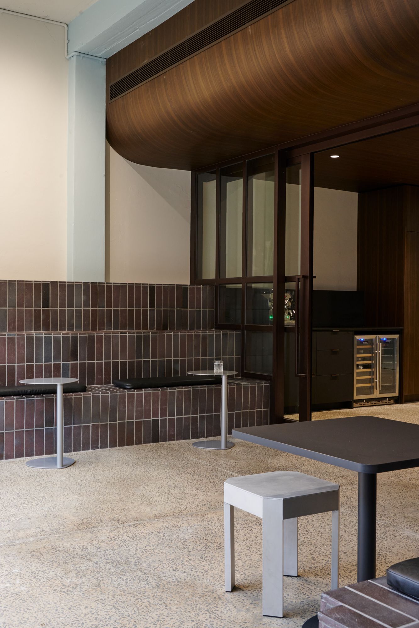 A portrait image of a tiered brick sitting that looking into a staff kitchen inside an office space. | LSR Workplace by Made For | South Melbourne | Veeral Patel
