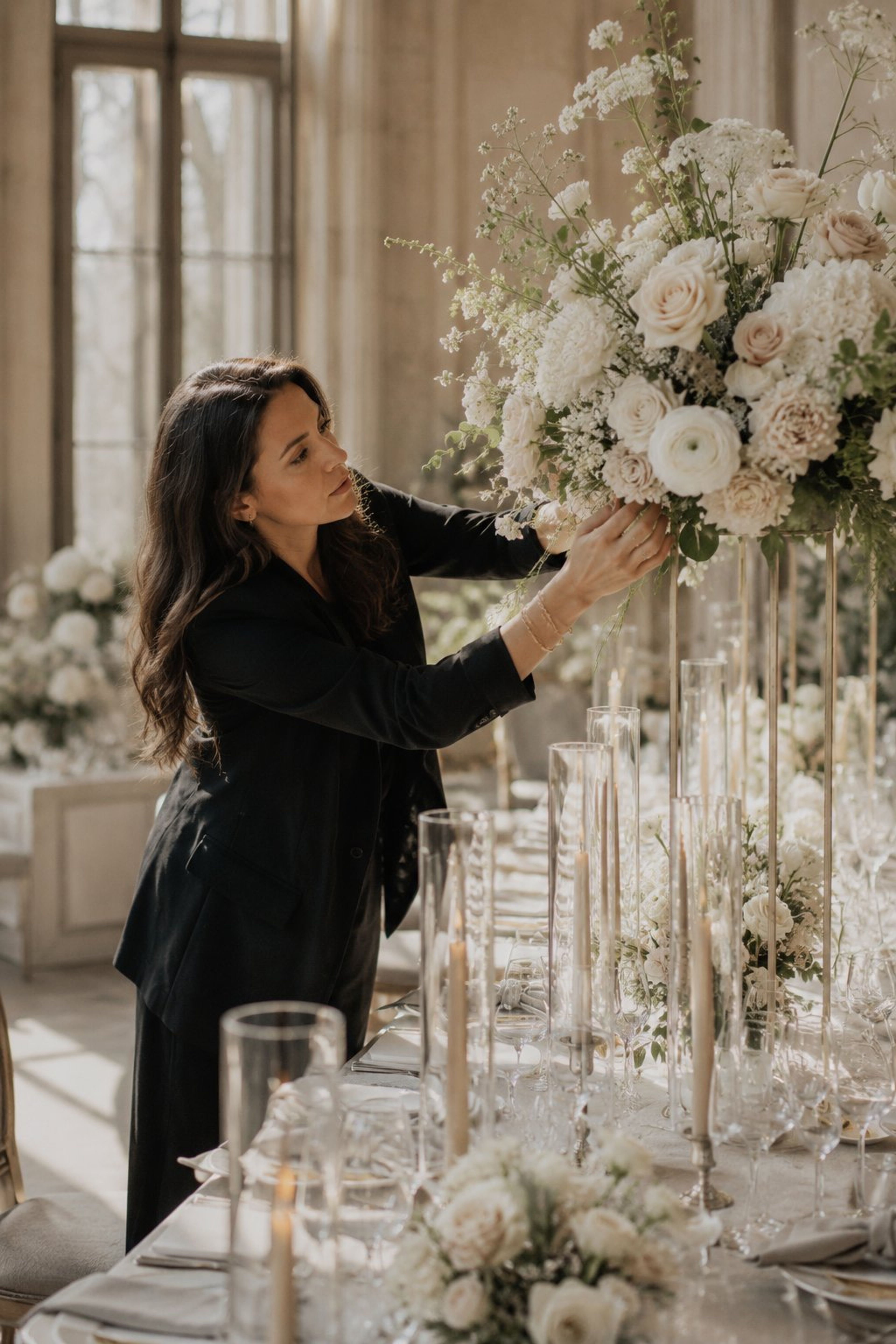 Wedding planner arranging white floral centrepieces