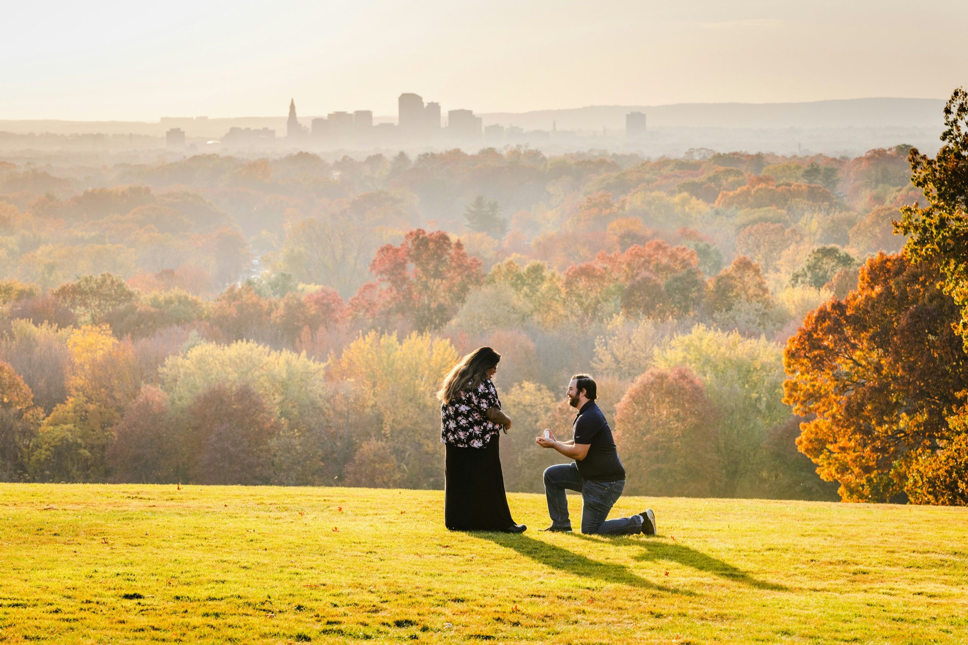 Marriage proposal at sunrise overlooking a valley