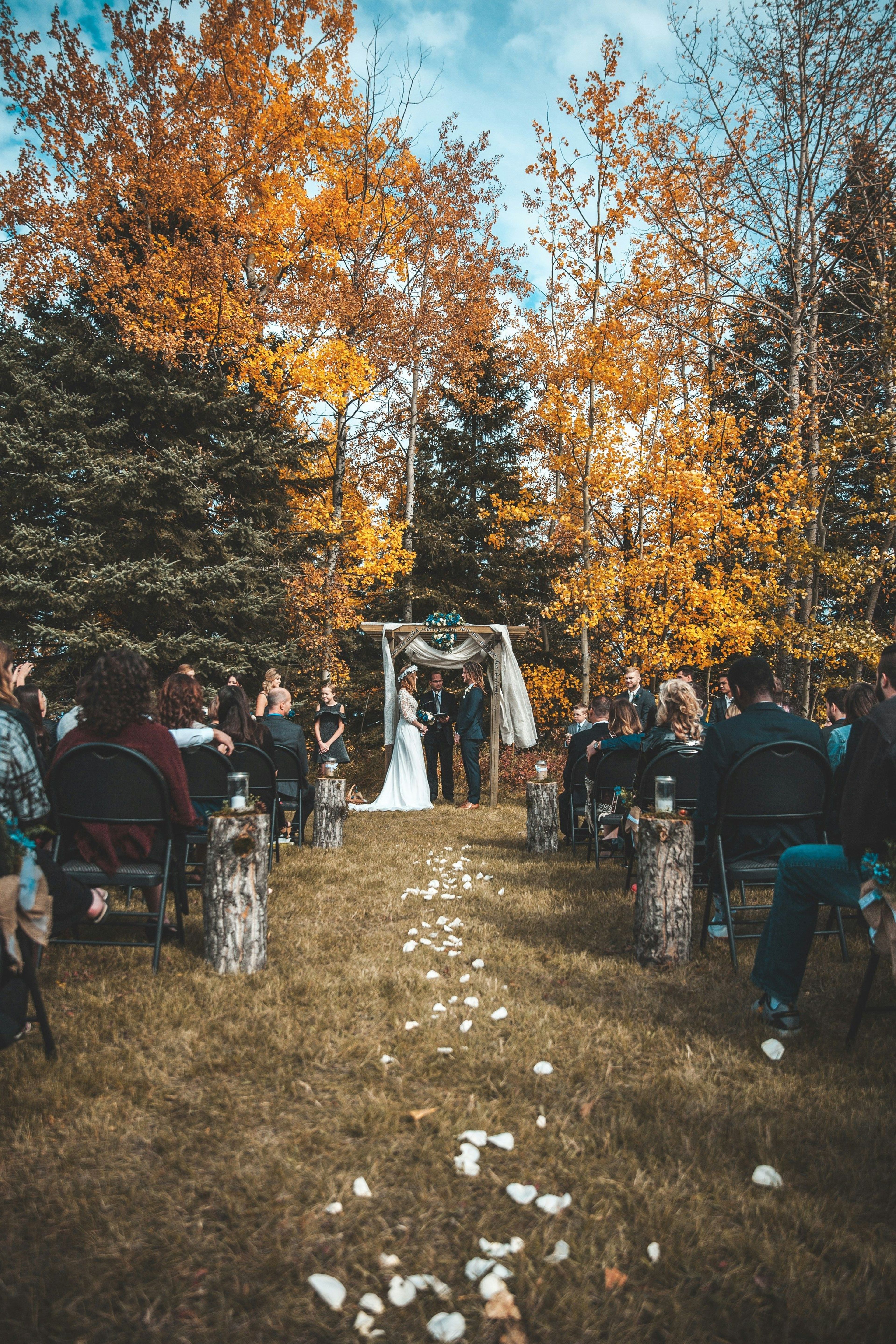 Outdoor autumn wedding ceremony aisle lined with petals