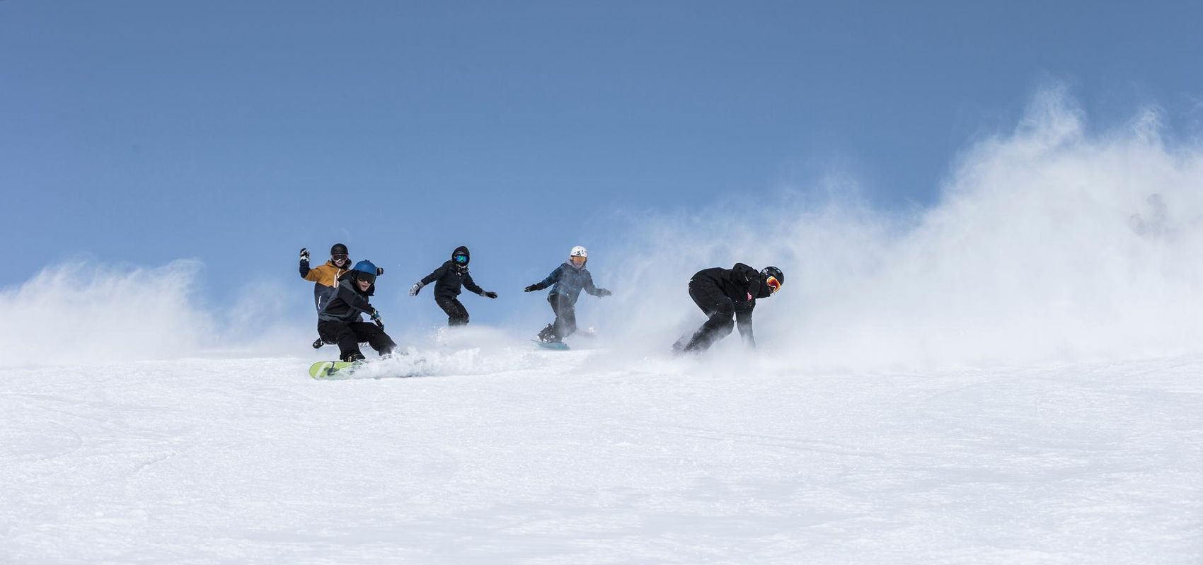 Groupe de snowboarders descendant la piste