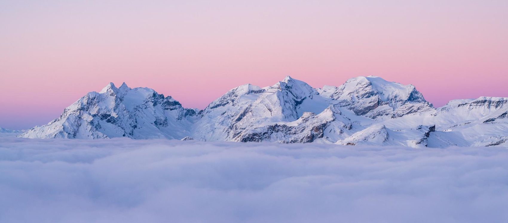Snow-covered mountain peaks in the evening red