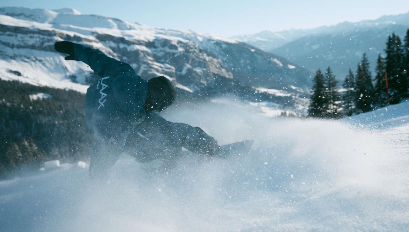 Snowboardlehrer macht ein Trick während dem er eine Kurve fährt