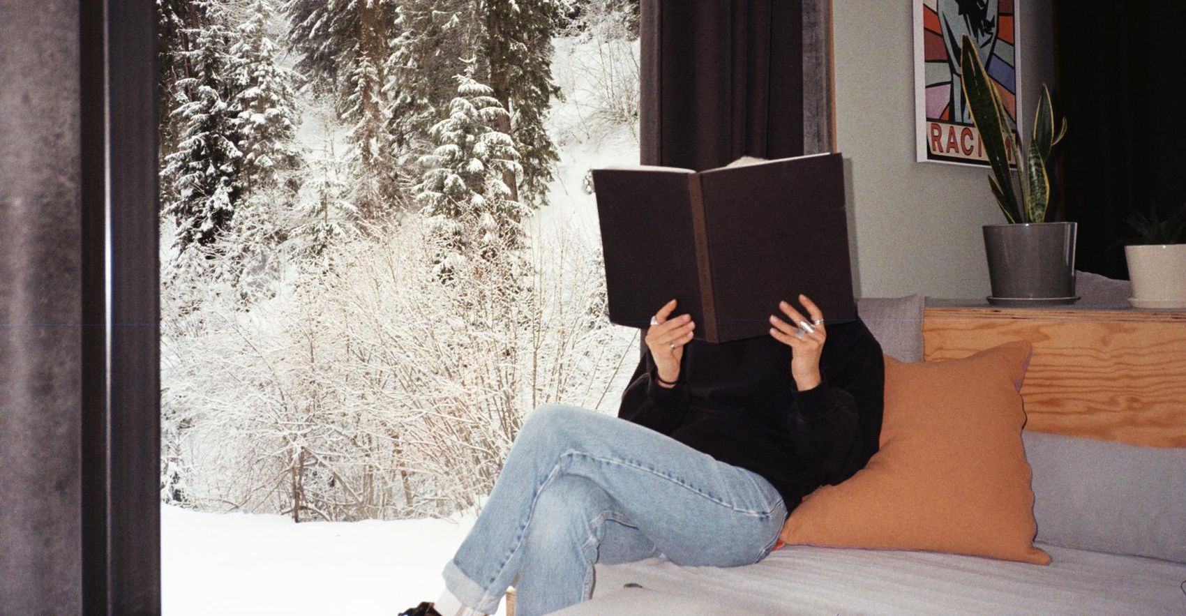 Woman sits behind book and reads