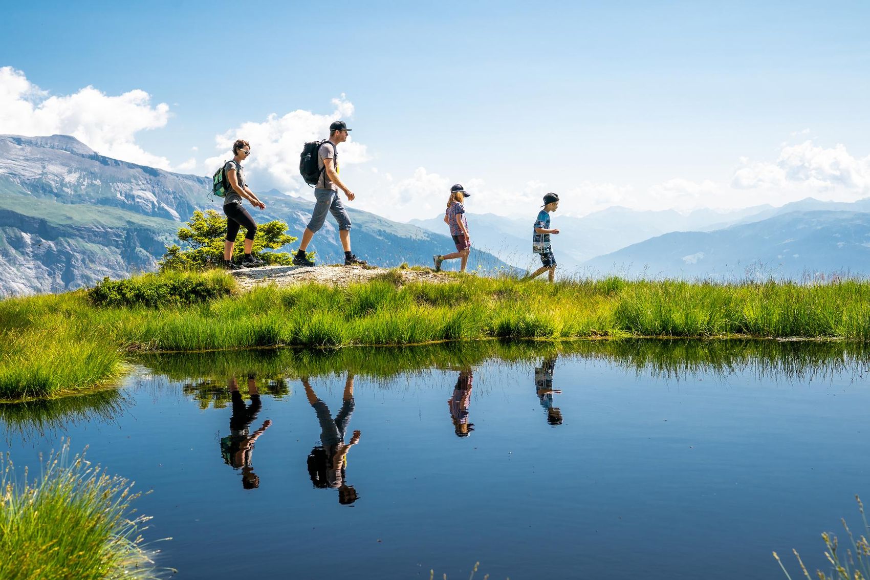 Familie läuft an einem See vorbei