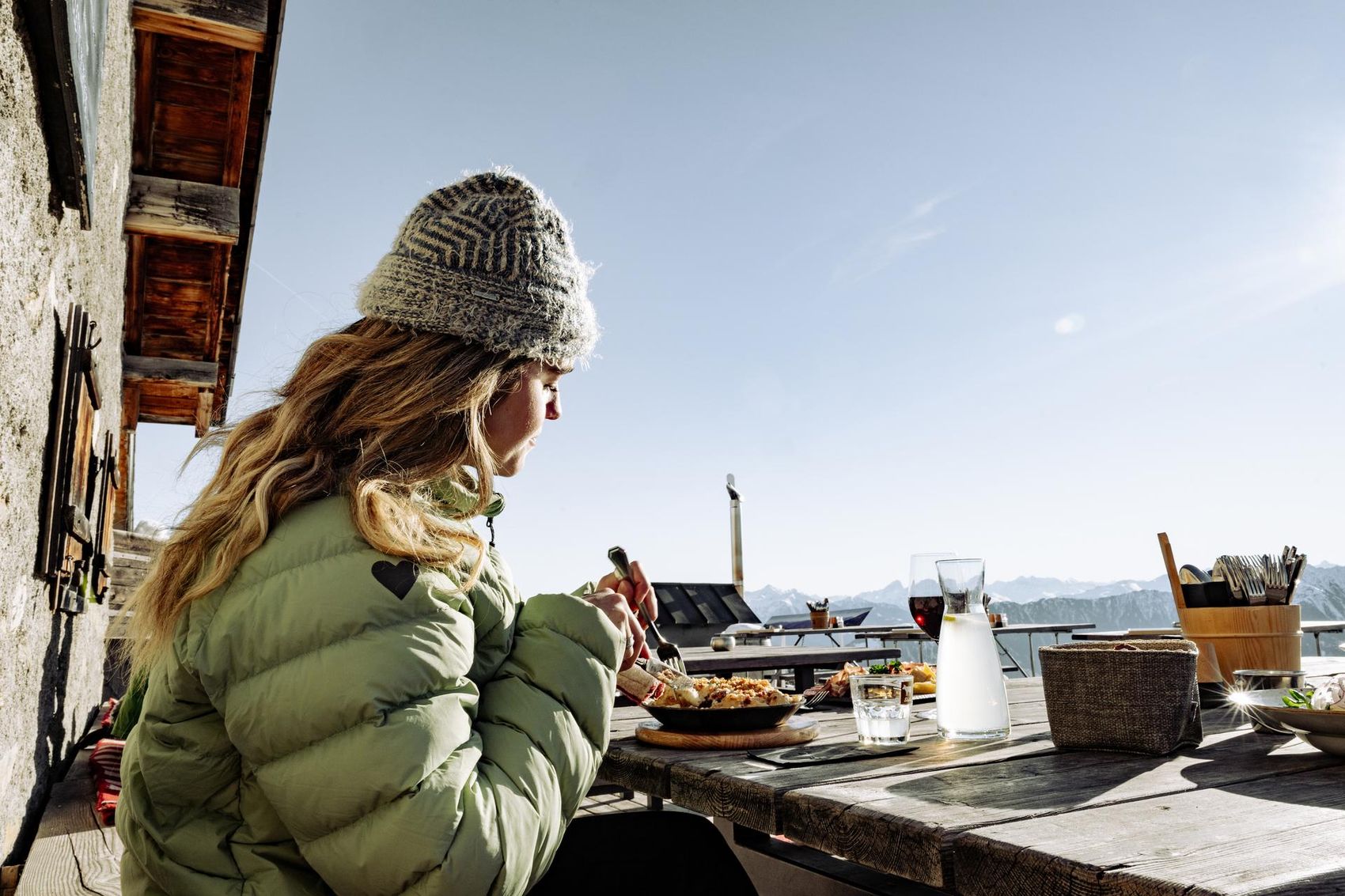 Frau isst auf der Stalla Terrasse