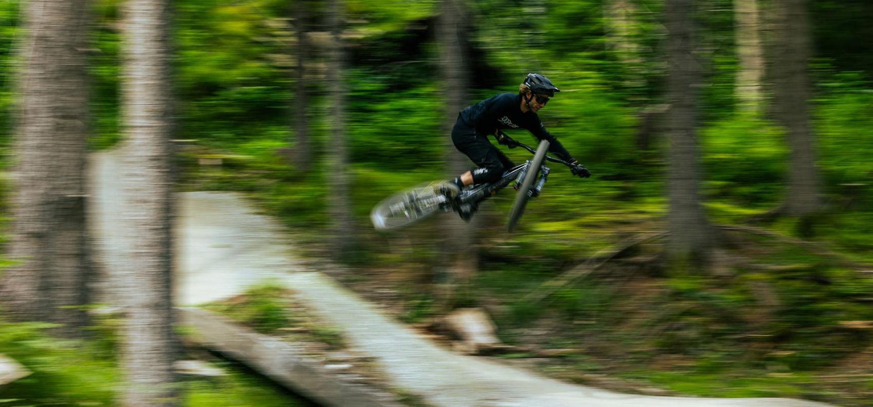 Biker springt über Kicker auf dem Biketrail