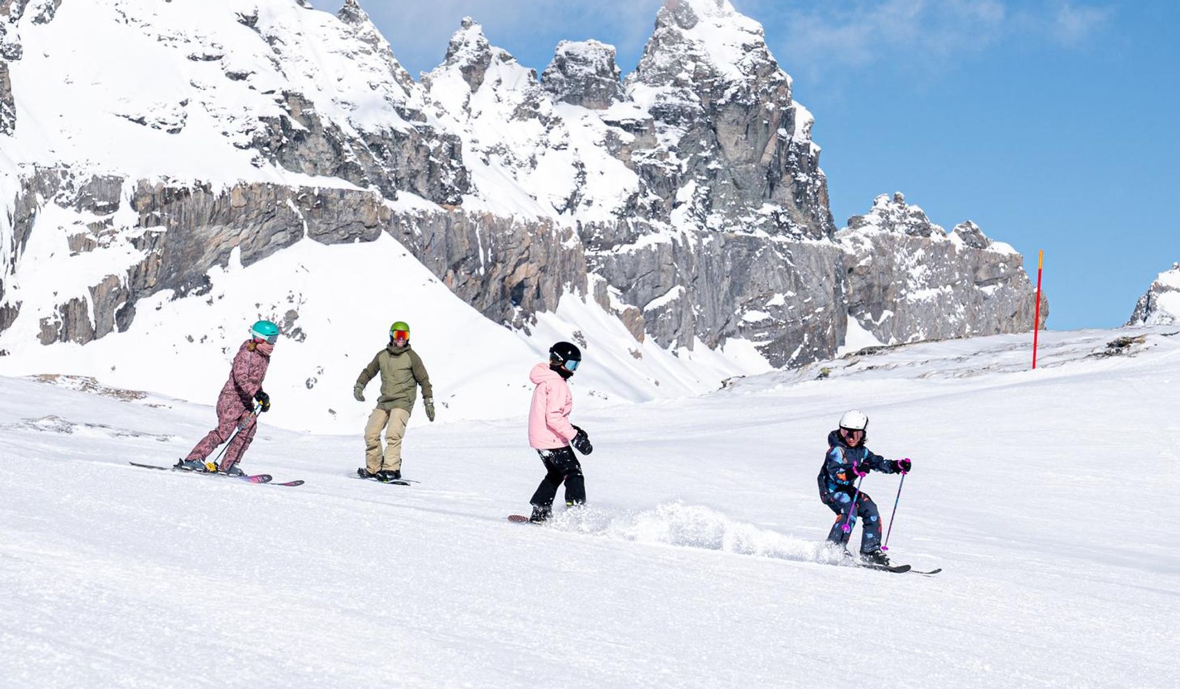 Snowboarder doing a trick on a box, with the signina mountain group in the background.