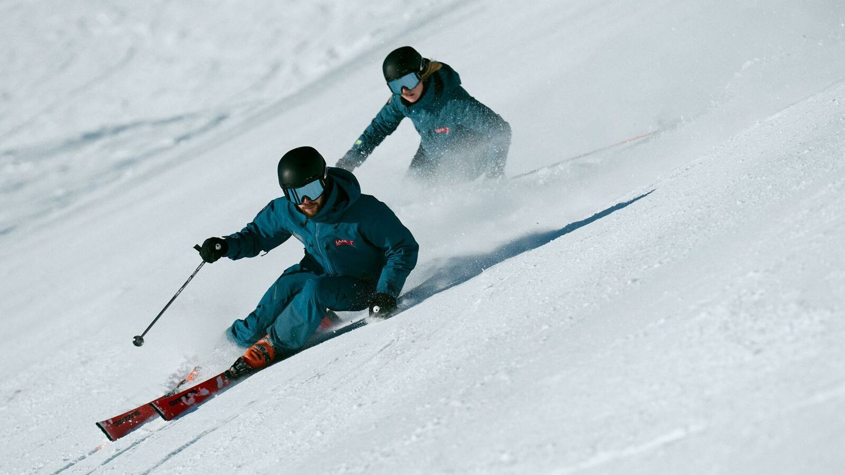 Skifahrer fahren in einer Kurve hintereinander