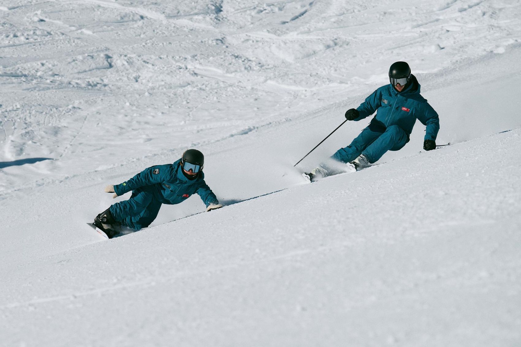 Skifahrer und Snowboarder fahren auf der Piste