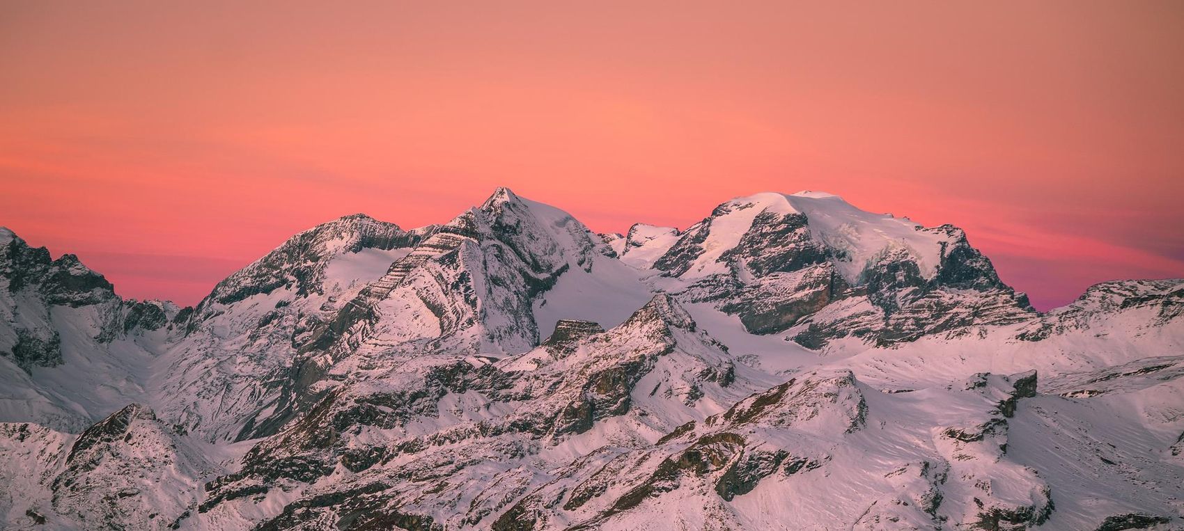 Verschneite Bergspitzen im Abendrot