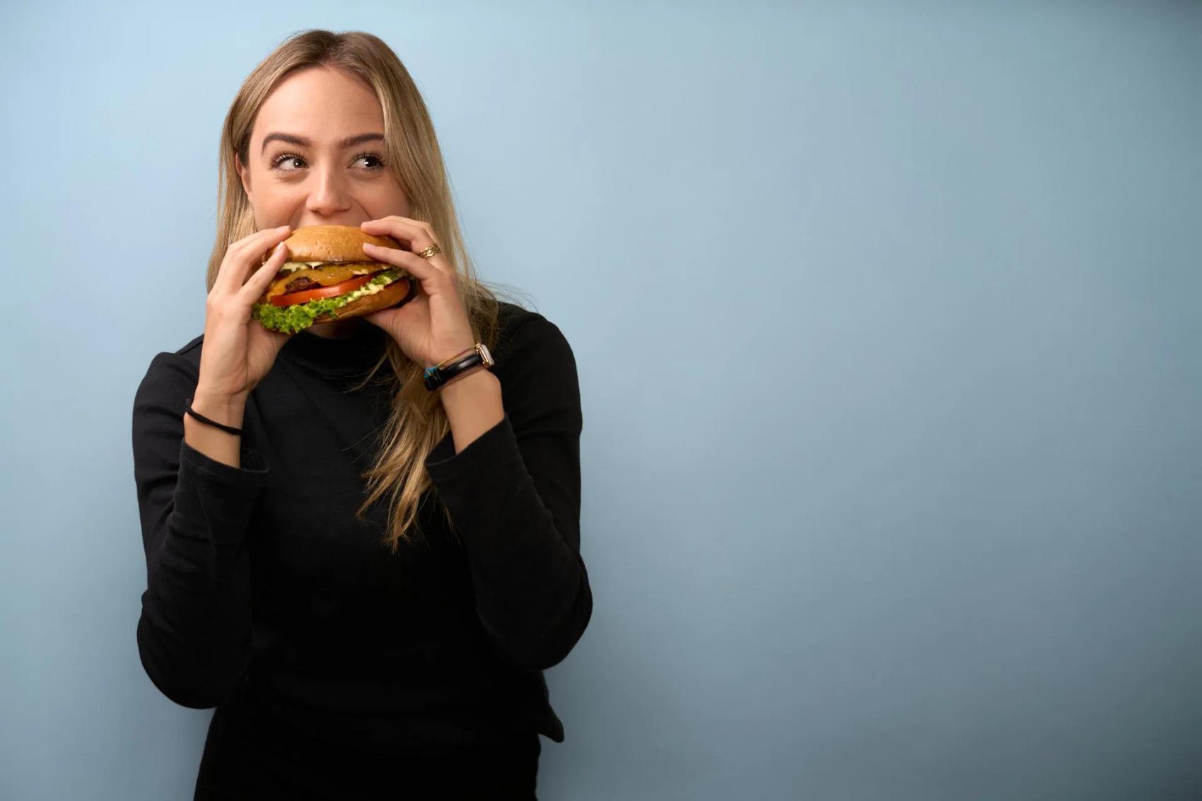 Woman bites into burger