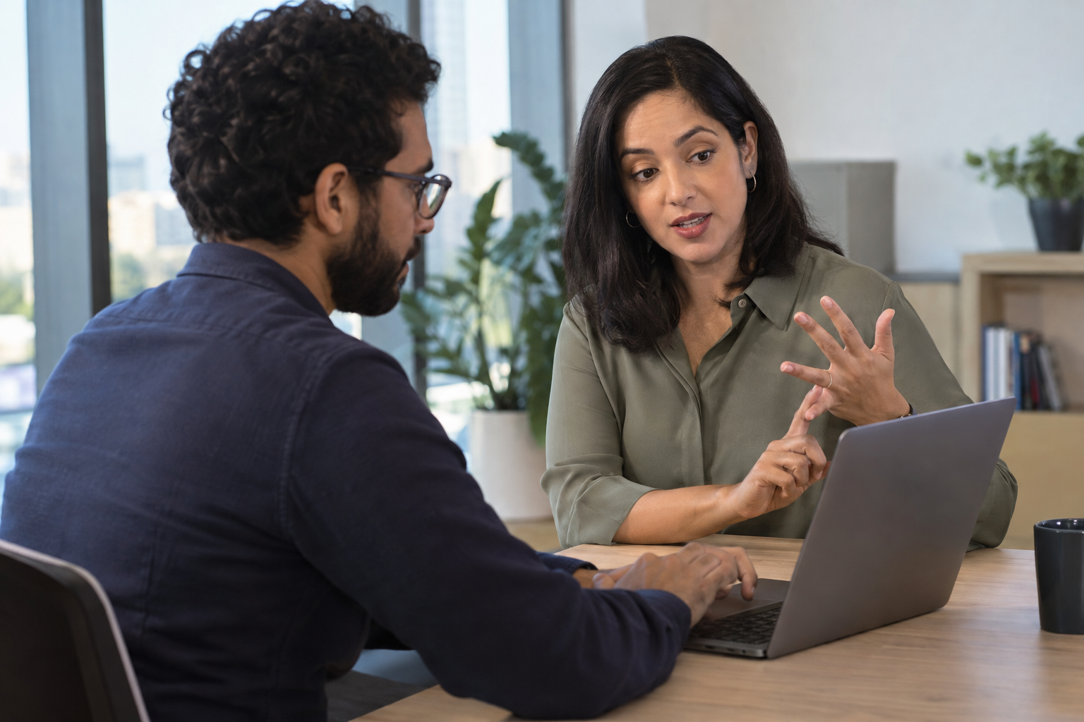 An HR operations lead and people analyst work together at a laptop to select initial workforce metrics.