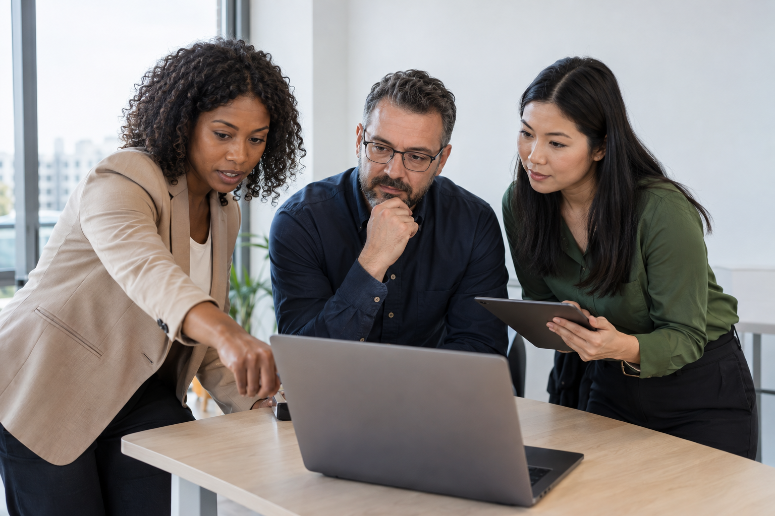 Three operations and risk professionals review AI agent oversight together using a laptop and tablet.