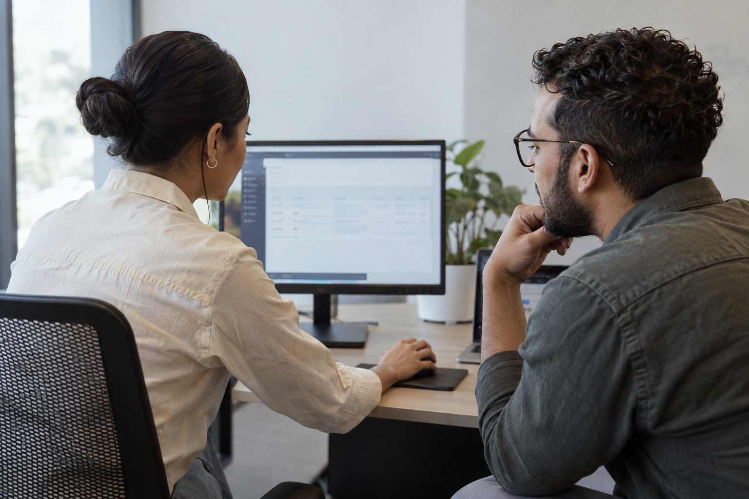 An operations coordinator and software engineer test a corrected automated handoff together at a workstation.