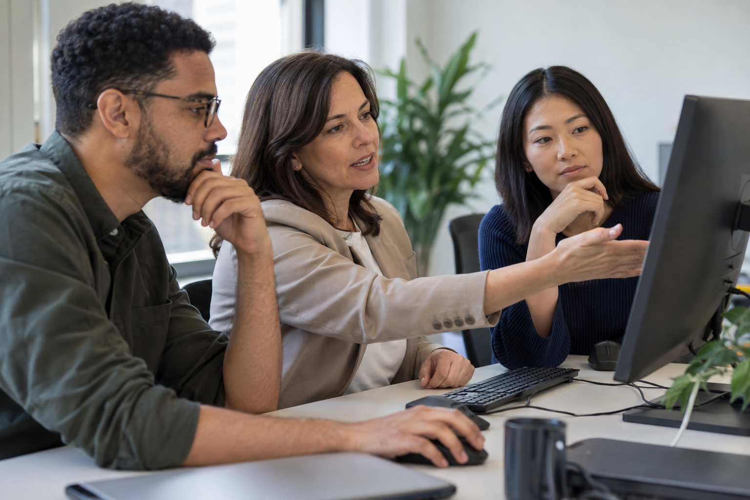 A business process director and two automation specialists discuss AI agent authority and human approval requirements at a workstation.