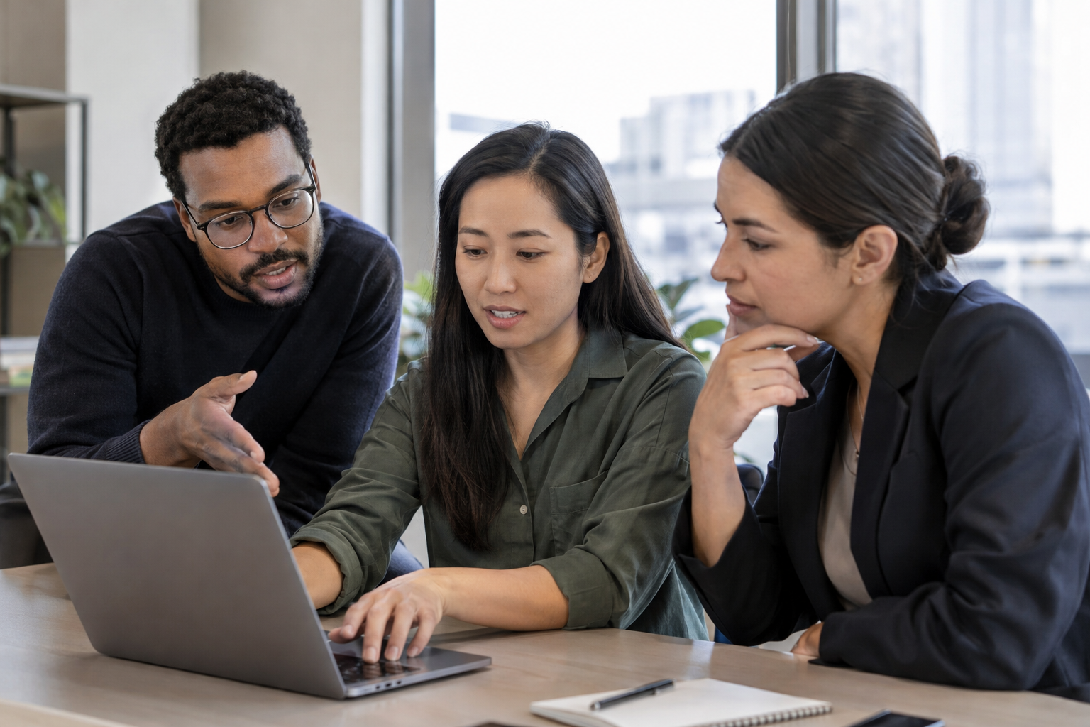 An operations specialist demonstrates a digital workflow to an automation engineer and team lead as they discuss an exception.