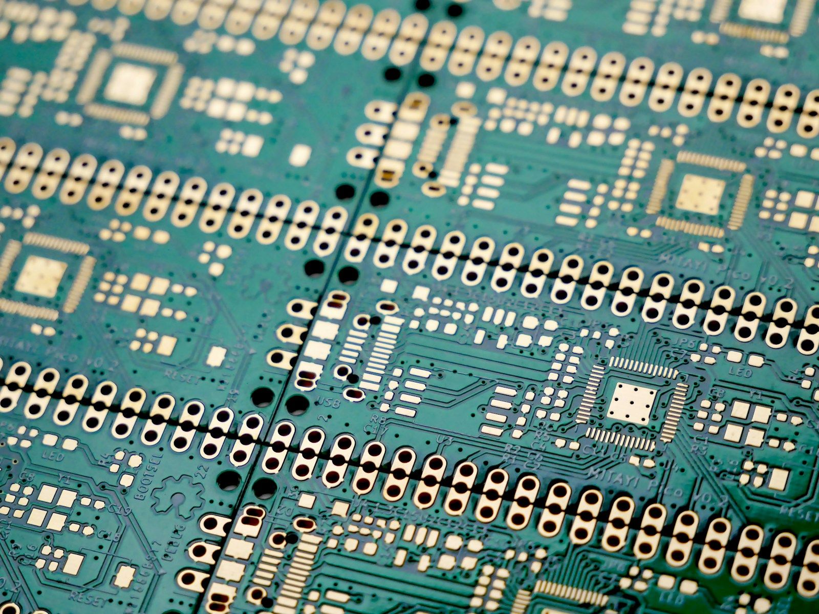Close-up of unassembled gold-finish printed circuit boards.