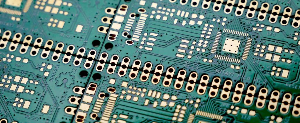 Close-up of unassembled gold-finish printed circuit boards.