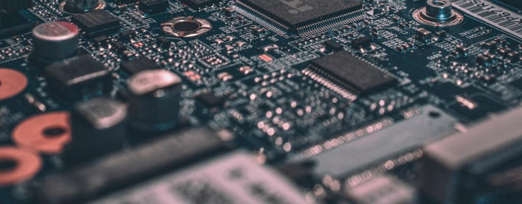 Close-up of a green printed circuit board with electronic components.