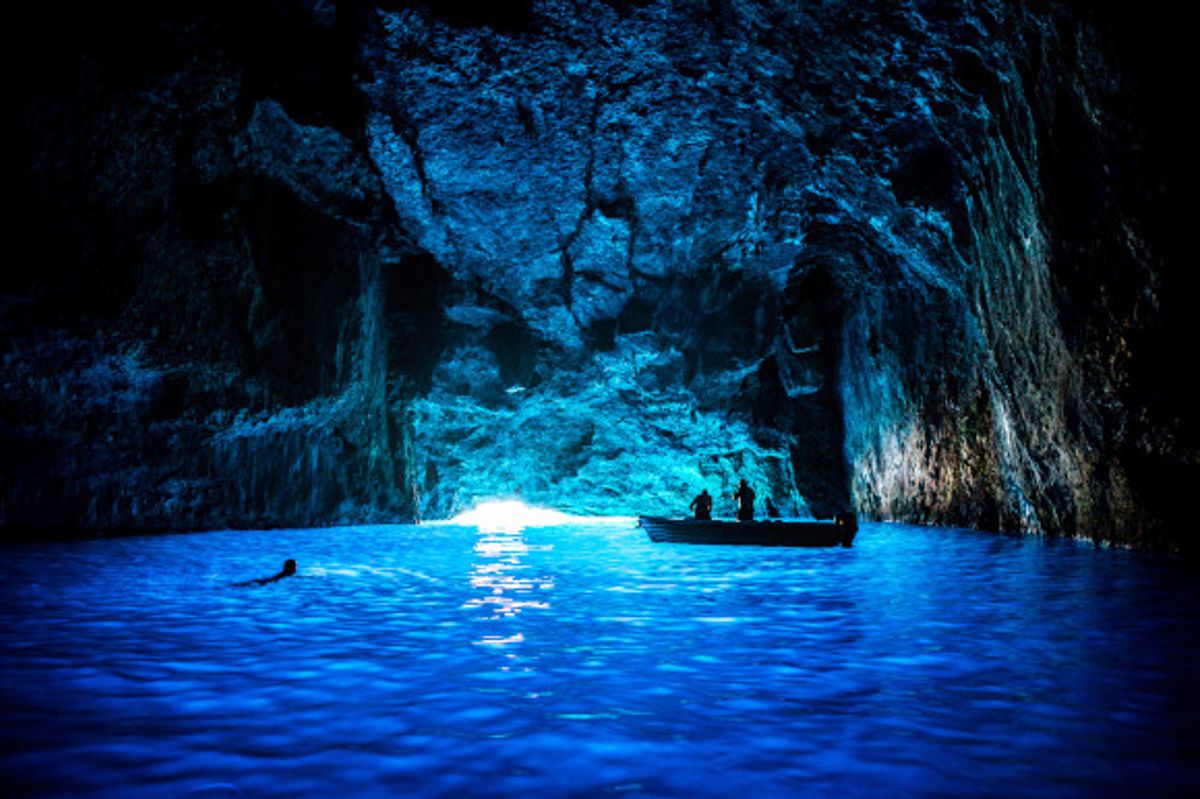 The dark caves of Kas featuring a small fishing boat and diver exploring