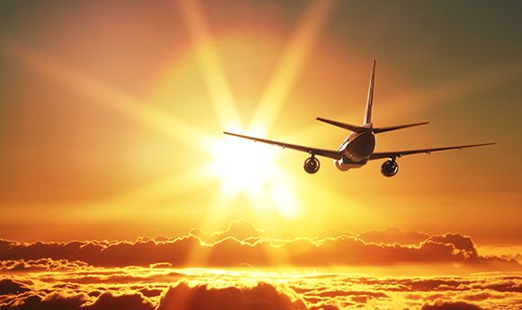 Plane flying towards beautiful sunset