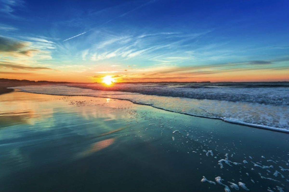 Early evening as the sunsets on the beach over the sea