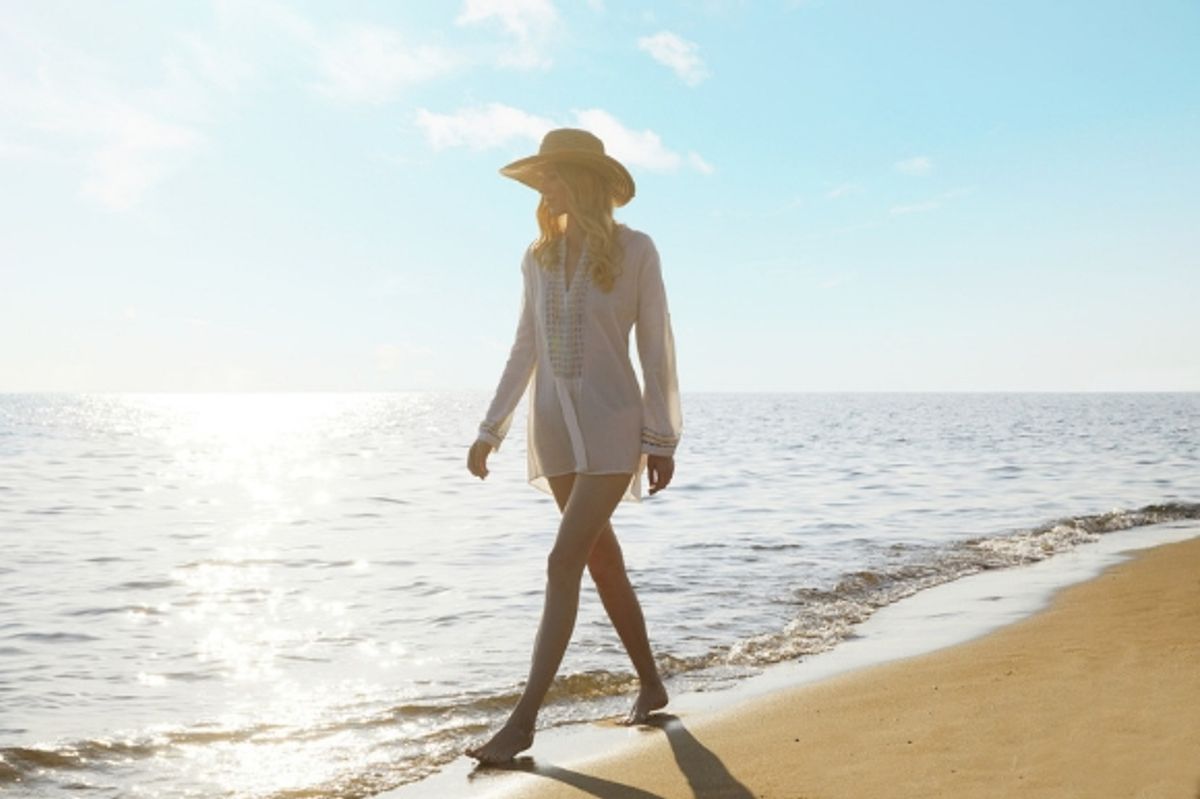 Woman walking along the sand as part of Ikos resort's beach lifestyle concept