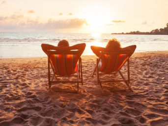 Couple sitting in deckchairs on the beach
