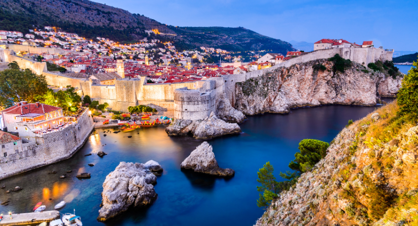 Dubrovnik at dusk with lights reflecting over the coastline