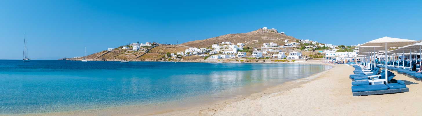 Sun loungers on the golden sandy beach in Elia, Mykonos