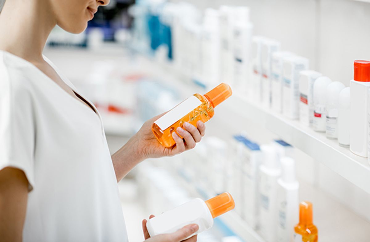Woman choosing sunscreen lotion at shop