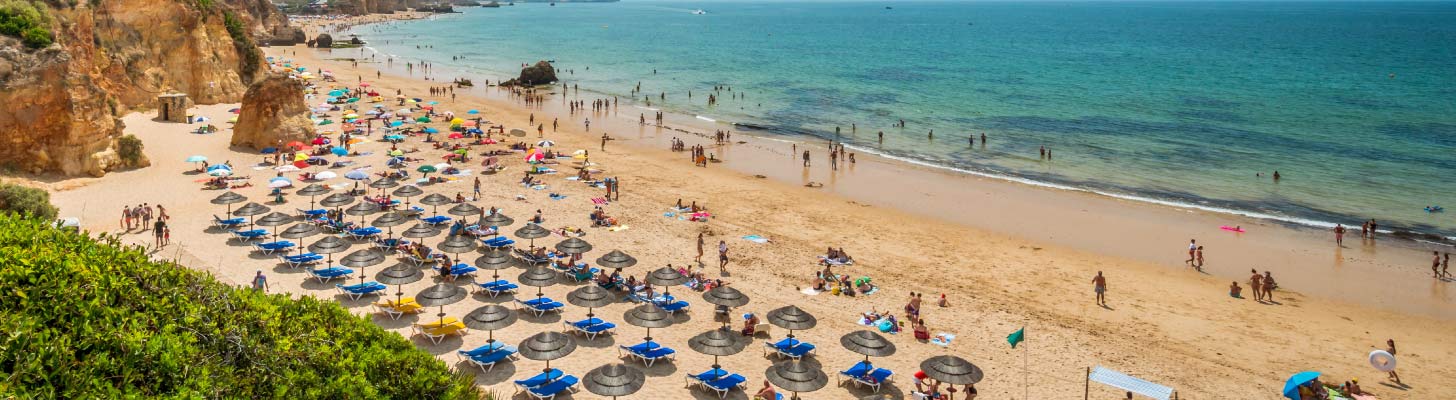 Sun loungers & umbrellas on the beach at Alvor, Portugal