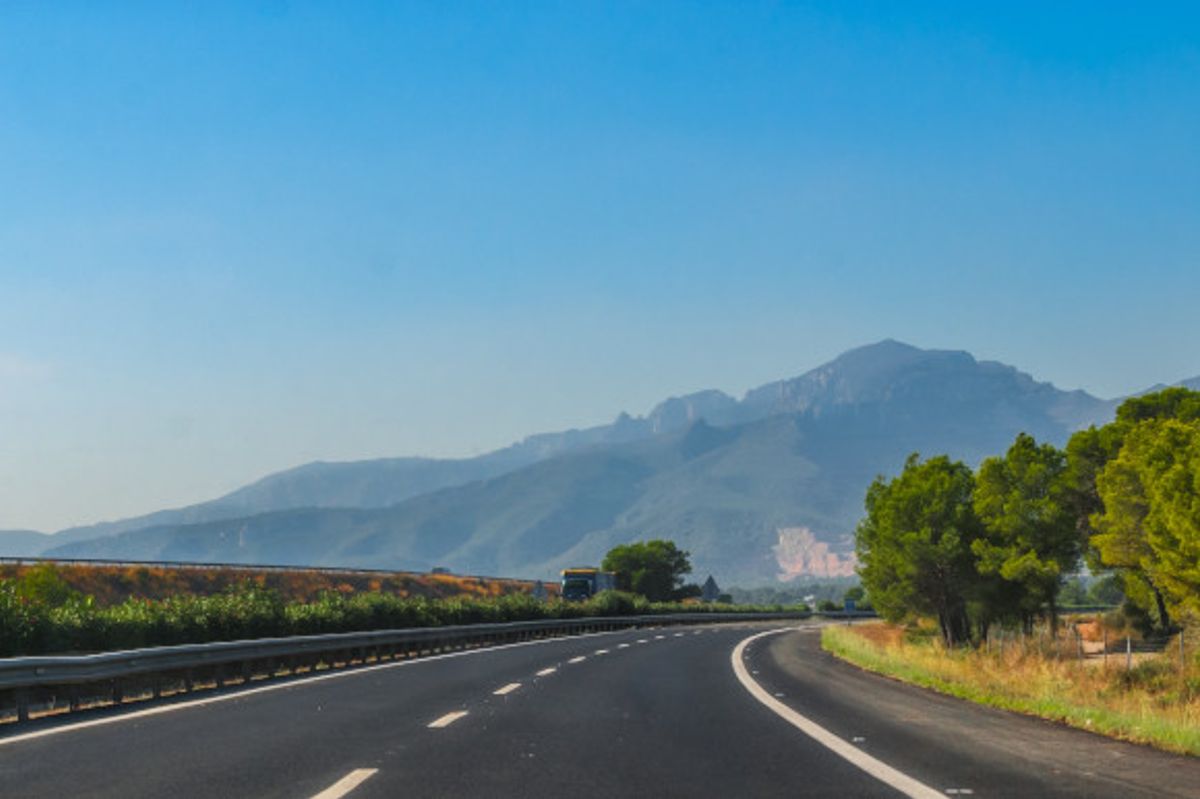 Warm sunny day in Spain and the Road to Madrid surrounded by mountains and lushest greenery