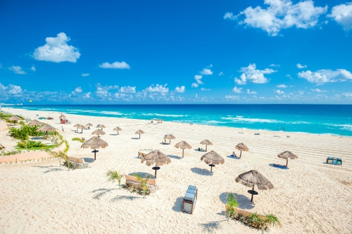 Cancun Beach in Mexico with straw umbrellas and tropical waters