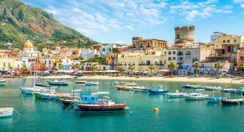 Harbour on Ischia with boats in the foreground and colourful buildings in the background