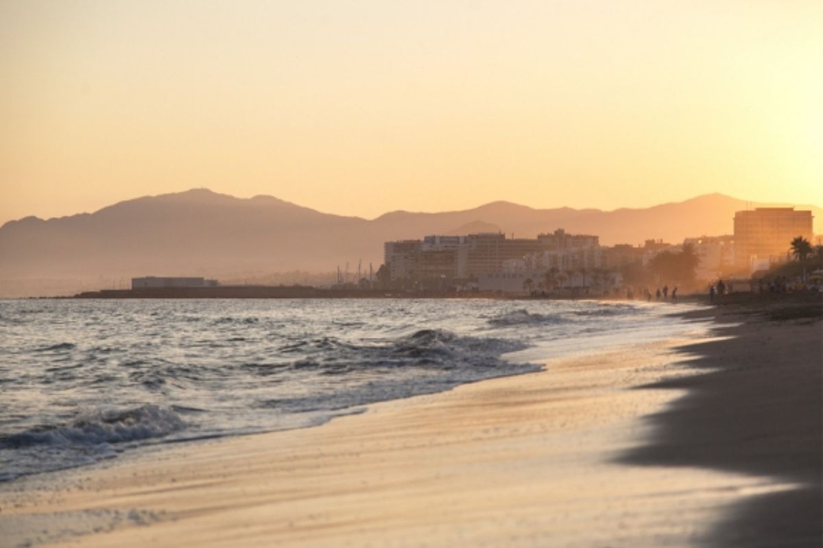 A sunset view of Bounty Beach in Marbella backed by surrounding buildings