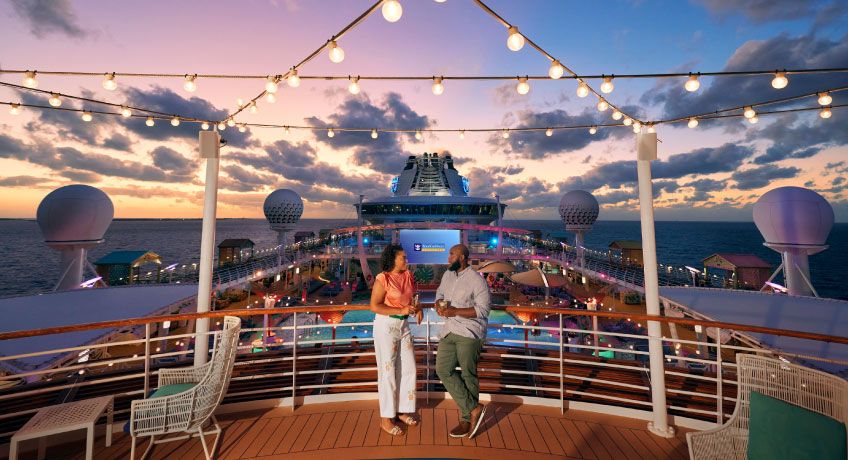 Couple relaxing on top deck of the Freedom of the Seas at dusk