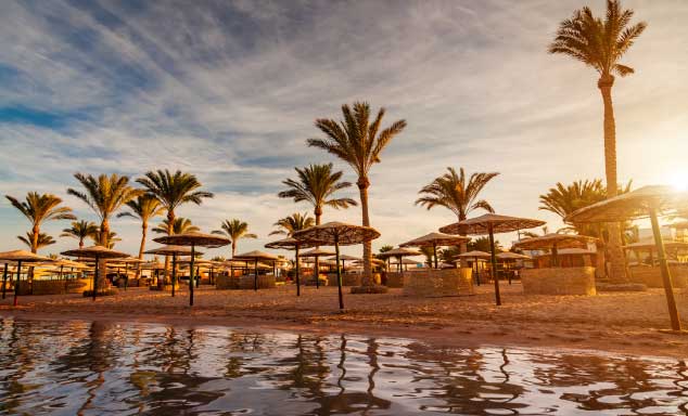 Beach umbrellas on a beach at sunset in Hurghada