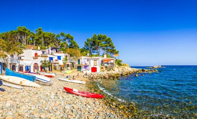 Canoes & boats on the shore with traditional houses in the background